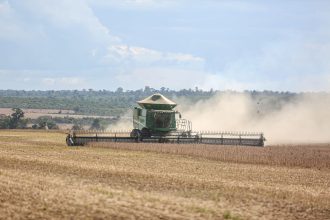 Colheitadeira trabalha em uma extensa plantação de soja no Brasil.