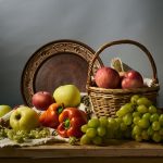 Composição de maçãs, uvas e peras, acompanhadas de outros produtos agrícolas, dispostas sobre uma superfície rústica.