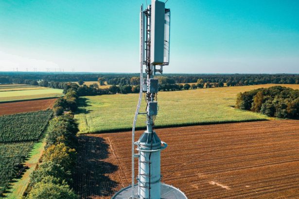 Torre de telefonia celular em meio a uma extensa área de cultivo.